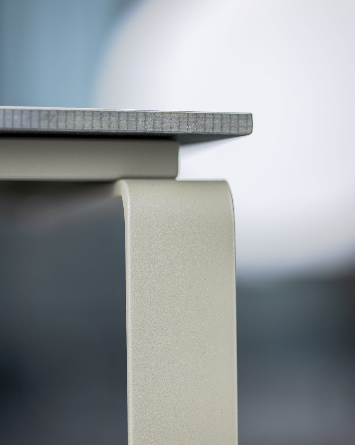 Detailansicht der Tischkante des ALTO Beistelltischs mit dunkler Platte, zeigt hochwertige Verarbeitung und modernes Design.