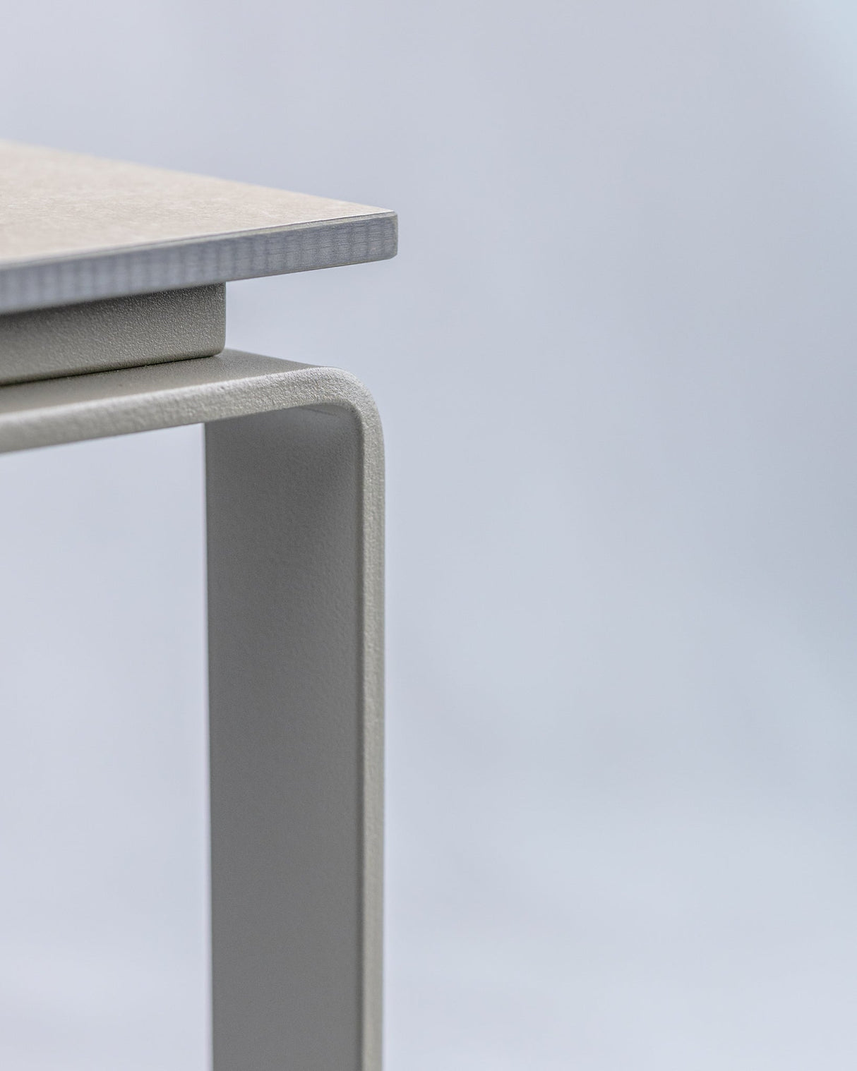Minimalistisches Design des ALTO Beistelltischs aus Edelstahl, Detailansicht der Tischkante mit klarer Linienführung.