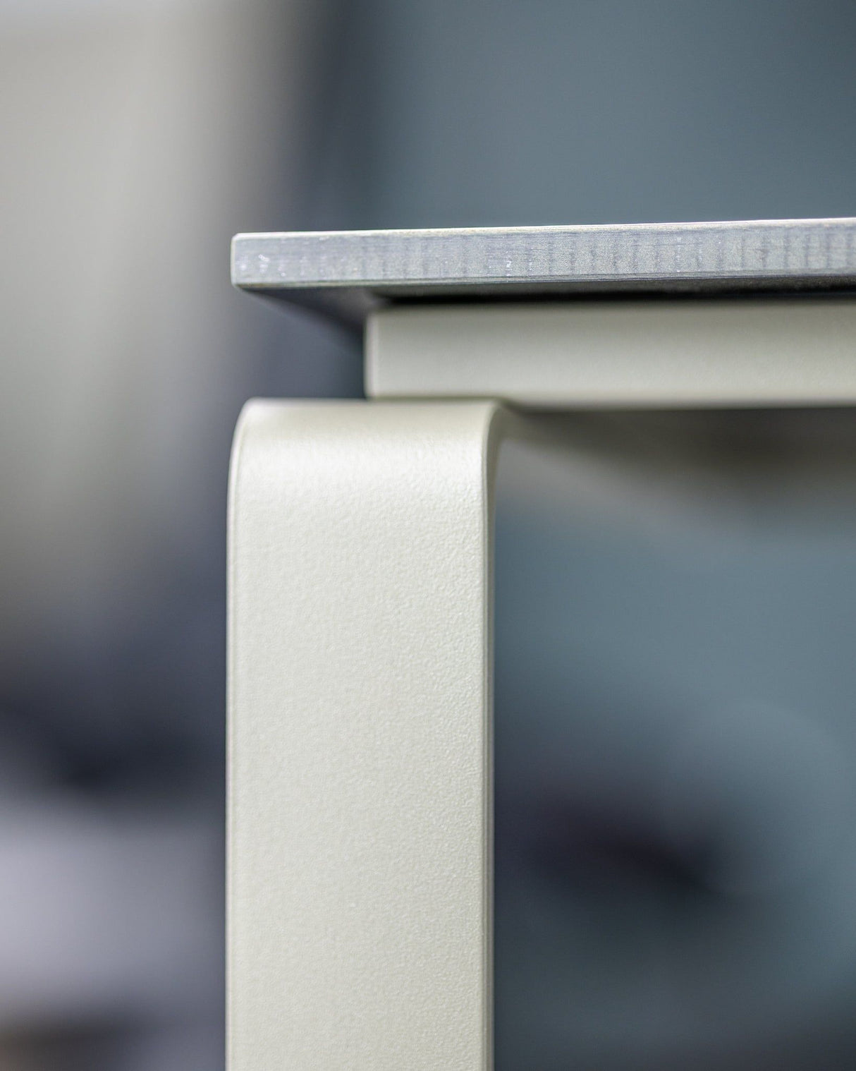 Nahaufnahme der Kante des ALTO Beistelltischs, zeigt die robuste Verarbeitung und das moderne Design aus Edelstahl.