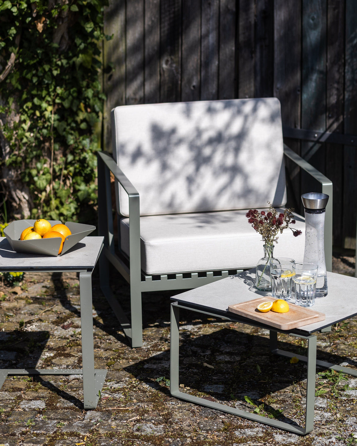 ALTO – Beistelltisch (Edelstahl, pulverbeschichtet) als Teil einer Outdoor-Sitzgruppe, funktional und dekorativ im Gartenambiente.