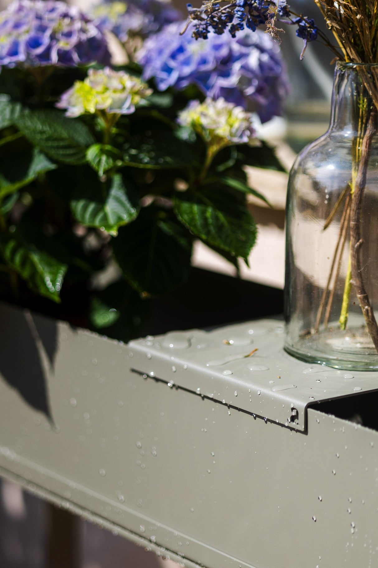 Detailansicht des CUBO - Pflanzbehälters mit Wassertropfen auf der Oberfläche, wetterfest und ideal für den Außenbereich.