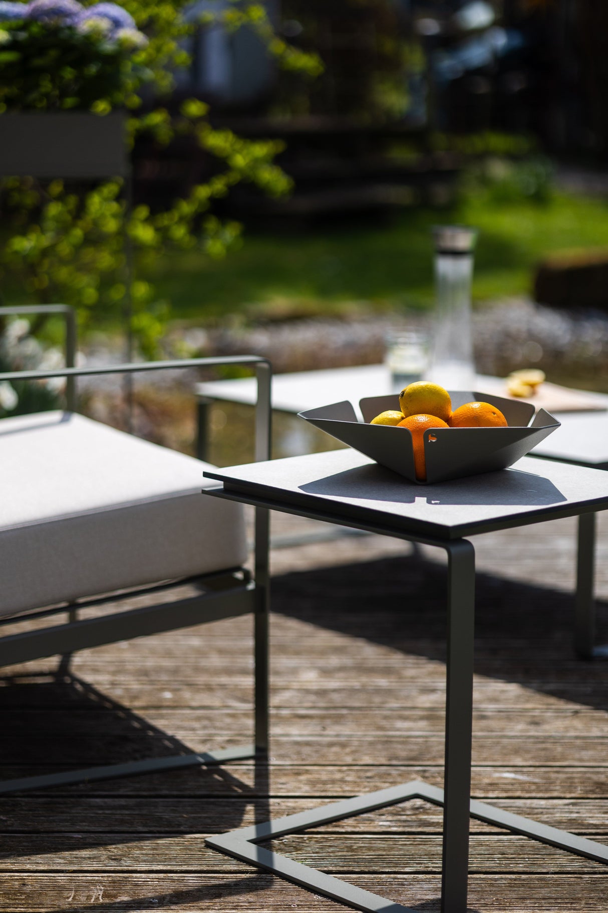 ALTO – Beistelltisch (Edelstahl, pulverbeschichtet) im Outdoorbereich neben Loungesessel, perfekt als stilvoller Gartentisch einsetzbar.