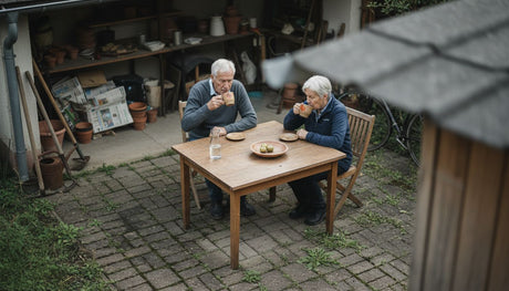 Ein älteres Ehepaar genießt gemeinsam die Zeit am Gartentisch auf der Terrasse.