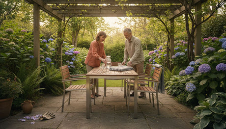 Ein Paar richtet im Garten hochwertige Gartenmöbel her und sorgt so für eine gemütliche Atmosphäre im Freien.