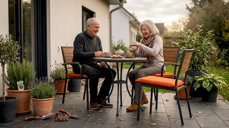 Ein älteres Ehepaar genießt die Zeit gemeinsam auf der Terrasse und macht es sich auf den Gartenmöbeln bequem.