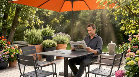 Ein Mann sitzt entspannt auf wetterfesten Gartenmöbeln und liest die Zeitung.