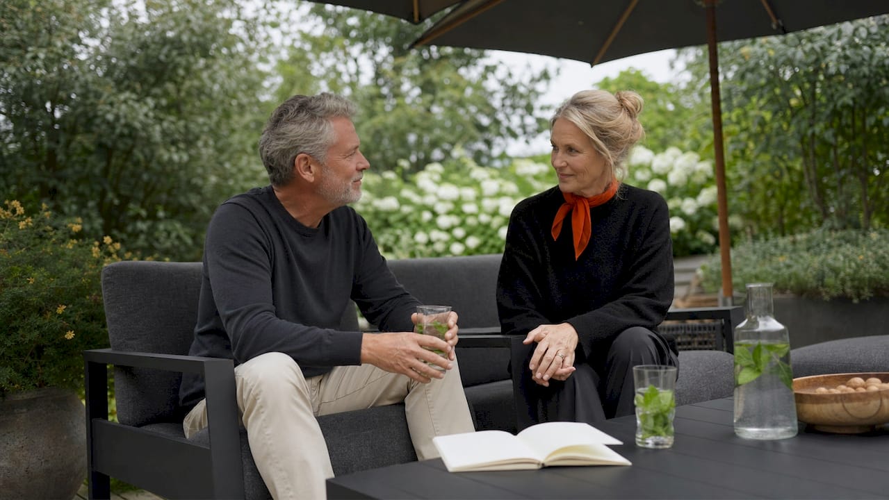 Ein älteres Ehepaar genießt entspannte Stunden auf ihrer Terrasse, die mit umweltfreundlichen Gartenmöbeln ausgestattet ist.