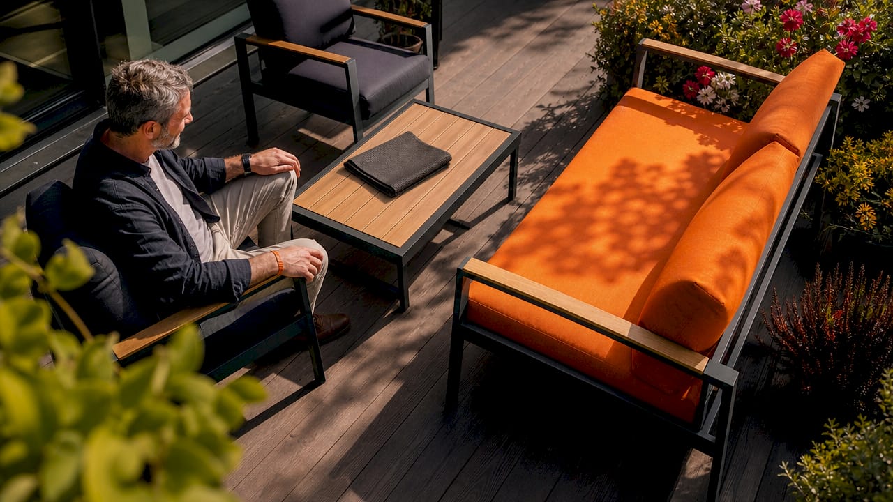 Ein Mann begutachtet die Gartenmöbel auf seiner Terrasse.