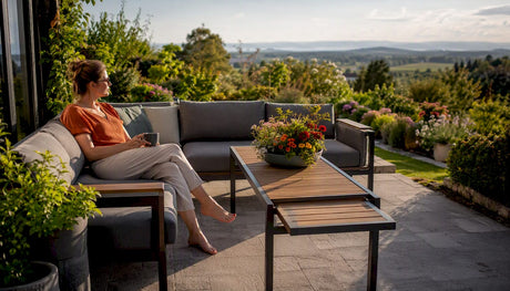 Eine Frau entspannt sich auf einer modularen Gartencouch auf der Terrasse.