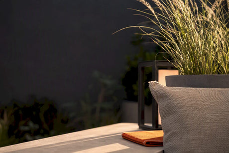 Gestylte Terrasse mit Textilien und Pflanzgefäßen
