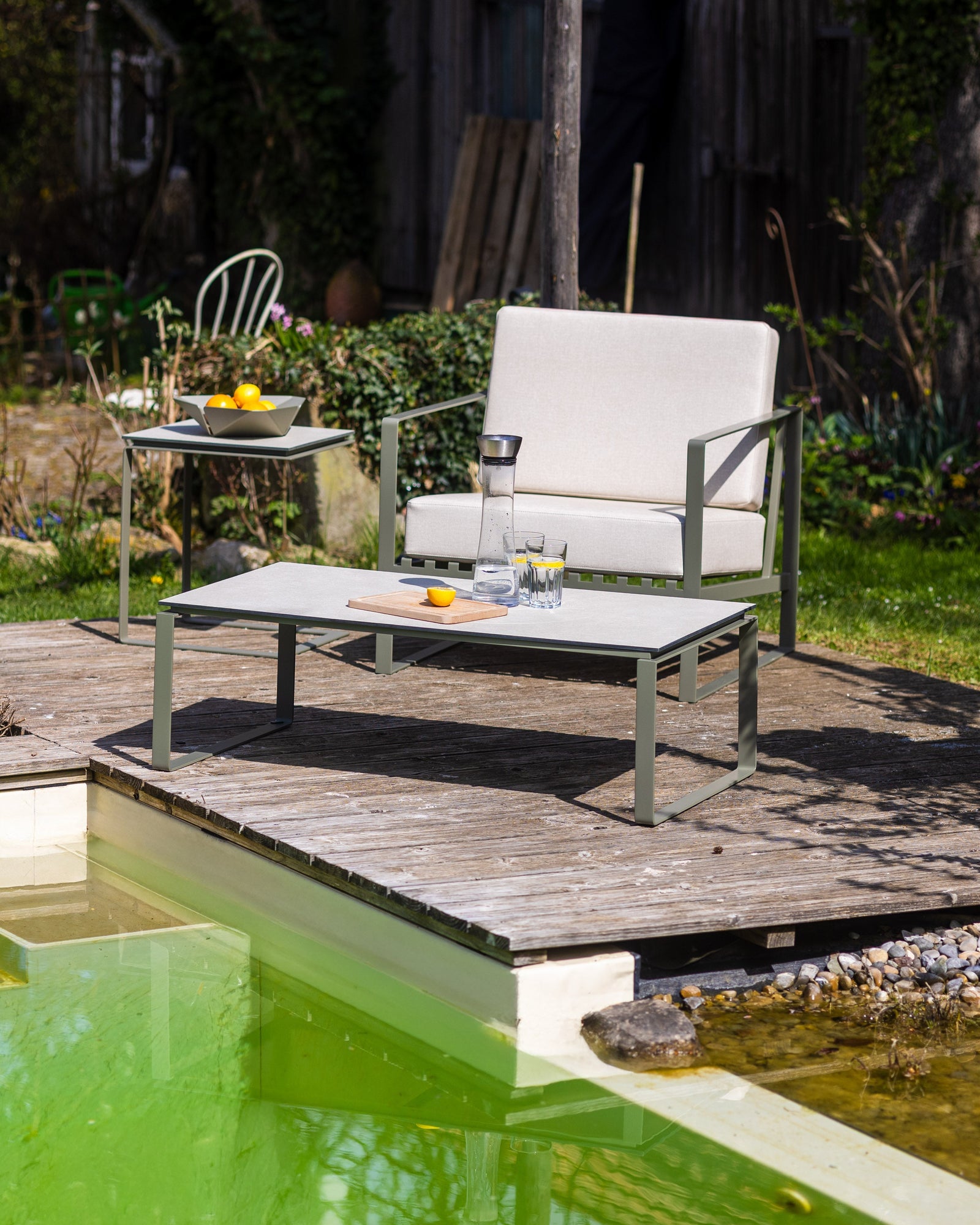 Alt-Text (Deutsch):  
Stilvolle Outdoor-Möbel auf Holzterrasse am Pool mit modernem Design.