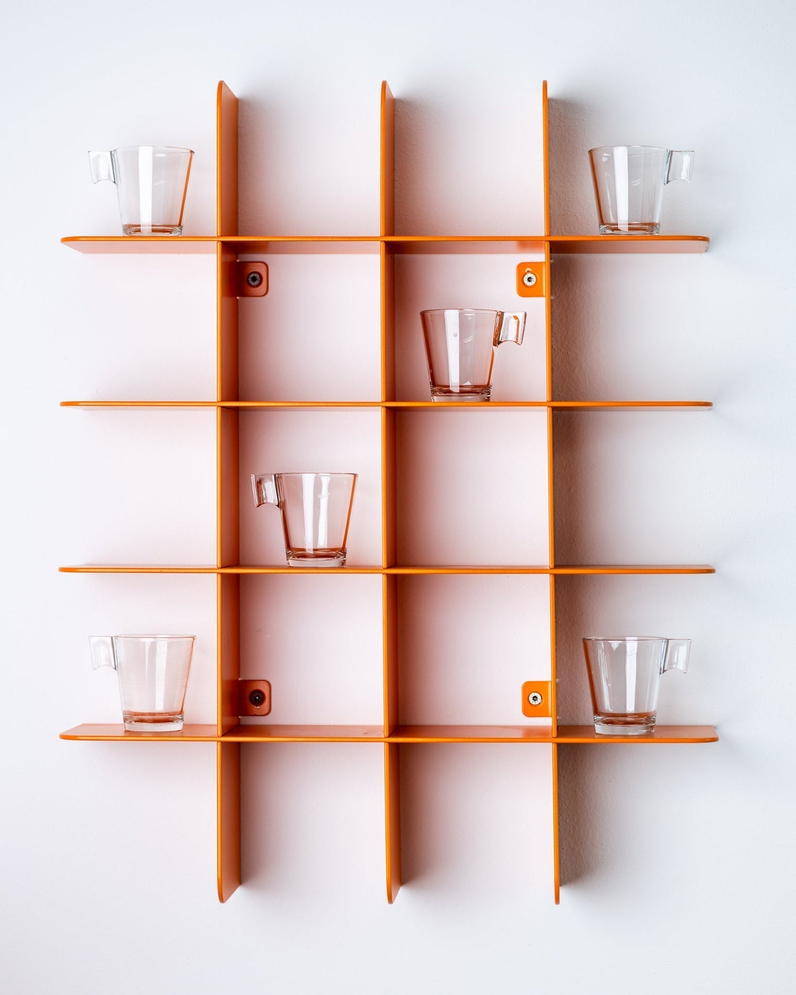 Alt-Text (Deutsch):  
Modernes orangefarbenes Wandregal mit Glastassen als Farbakzent in kleiner Küche.